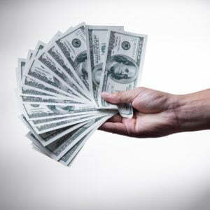 a hand holding a stack of cash