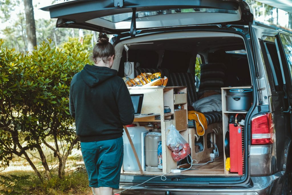 a man standing next to a truck full of produce