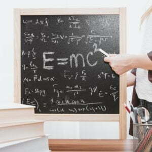 a person writing on a chalkboard