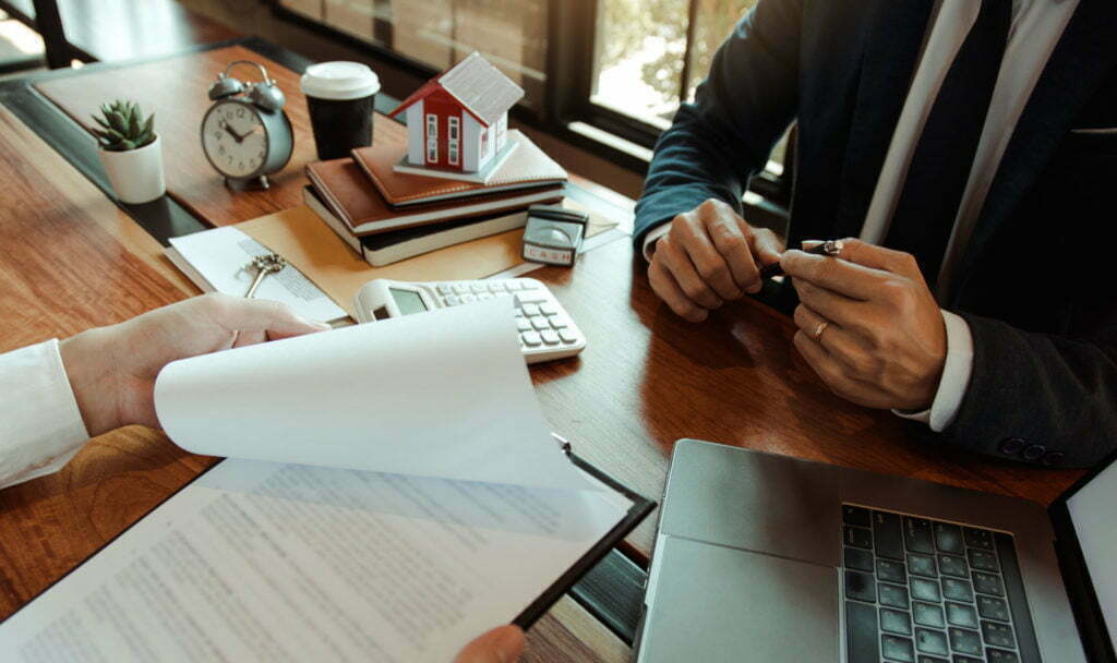 Customers buying houses are negotiating about the cost of home insurance with agents.