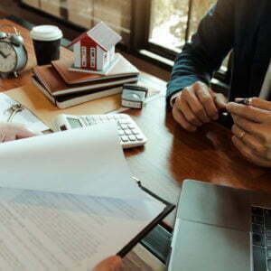 Customers buying houses are negotiating about the cost of home insurance with agents.